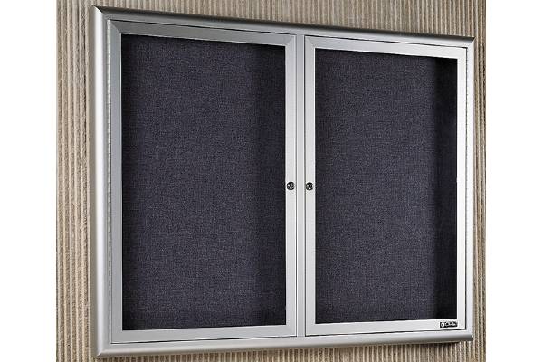 Radius edge cabinet is constructed of 1-1/2” x 3” hollow tube perimeter trim with satin anodize finish; inside depth is 1-3/4”. Tackable back panels can be Claridge Cork, Fabricork, or Designer Fabric. 3/16” tempered glass doors have continuous hinges and flat key tumbler locks. Z-bar hangers